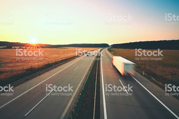 Traffic on the highway at the sunrise